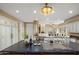 Open kitchen with cooktop island, bar seating, and view to other rooms at 11809 S Montezuma Ct, Phoenix, AZ 85044