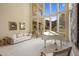 Sunlit living room with soaring windows overlooking beautiful views, a white piano, and classic furnishings at 11809 S Montezuma Ct, Phoenix, AZ 85044