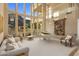 Bright living room with high windows offering backyard views, a white piano, and comfortable seating at 11809 S Montezuma Ct, Phoenix, AZ 85044