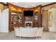 A view of a sitting area with a built-in shelf, fireplace, and a large TV screen at 11809 S Montezuma Ct, Phoenix, AZ 85044
