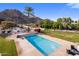 Inviting swimming pool with a fireplace feature and desert mountain views at 11809 S Montezuma Ct, Phoenix, AZ 85044