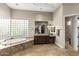 Primary bathroom featuring a soaking tub, privacy glass, and granite counters at 12006 E Yucca St, Scottsdale, AZ 85259
