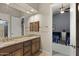 Bathroom featuring double sinks with granite counters, dark wood cabinets and access to bedroom at 12006 E Yucca St, Scottsdale, AZ 85259