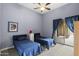 Bedroom with two beds, blue bedding, a ceiling fan and sliding glass door leading to patio at 12006 E Yucca St, Scottsdale, AZ 85259