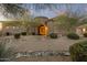 Elegant home entrance featuring a secure gated entryway, mature landscaping, and a desert-style front yard at 12006 E Yucca St, Scottsdale, AZ 85259