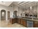 Kitchen with dark wood cabinets, travertine floors, and views into the living space at 12006 E Yucca St, Scottsdale, AZ 85259