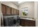 Laundry room with front loading washer and dryer and sink with granite counter top at 12006 E Yucca St, Scottsdale, AZ 85259