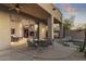 Covered patio with an outdoor dining set and view through open sliding glass door to living area at 12006 E Yucca St, Scottsdale, AZ 85259