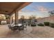 Covered patio with outdoor dining set overlooking a pool with a waterfall feature at 12006 E Yucca St, Scottsdale, AZ 85259