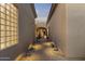Exterior walkway featuring stone pavers, small garden, and light-filled glass block window at 12006 E Yucca St, Scottsdale, AZ 85259