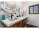 Modern bathroom featuring dual sinks, sleek faucets, marble backsplash, and stylish lighting at 1246 E Cambridge Ave, Phoenix, AZ 85006