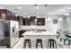 Modern kitchen features dark cabinets, stainless steel appliances, a granite island with seating and pendant lights at 12690 S 184Th Ave, Goodyear, AZ 85338