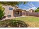 The backyard has a covered patio, grassy area, and block wall for privacy at 137 W Del Rio St, Gilbert, AZ 85233