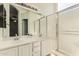 Well-lit bathroom with double sinks, vanity, large mirror, and a glass-enclosed shower at 137 W Del Rio St, Gilbert, AZ 85233
