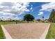 Sand volleyball court in community park with manicured lawns and mature trees at 137 W Del Rio St, Gilbert, AZ 85233