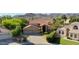 Beautiful aerial view of a desert home with a tile roof, three car garage, lush landscaping, and mountain views at 14034 S 34Th Pl, Phoenix, AZ 85044