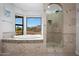 Bright bathroom featuring a soaking tub with beautiful outdoor views and a tiled walk-in shower at 14034 S 34Th Pl, Phoenix, AZ 85044