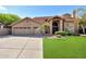 Charming home featuring a three-car garage, tile roof, lush green lawn, and desert landscaping at 14034 S 34Th Pl, Phoenix, AZ 85044