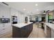 Spacious kitchen with white cabinets, a center island, stainless steel appliances, and an adjacent living area at 14034 S 34Th Pl, Phoenix, AZ 85044