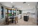 Modern kitchen featuring white cabinets, an island, stainless steel appliances, and an adjacent dining area with a view of the pool at 14034 S 34Th Pl, Phoenix, AZ 85044