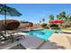 Sparkling pool with lounge chairs, umbrellas, desert landscaping, and a serene backyard setting at 14034 S 34Th Pl, Phoenix, AZ 85044