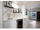 Stylish wet bar with modern finishes, custom backsplash, built-in wine fridge, and easy access to the patio at 14034 S 34Th Pl, Phoenix, AZ 85044