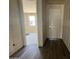 Hallway features beautiful wood-style tile flooring and a view into the unfurnished living area at 15785 W Cheryl Dr, Waddell, AZ 85355