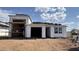 New home under construction with tile roof and open garage bays at 15785 W Cheryl Dr, Waddell, AZ 85355