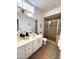Updated bathroom with a dual sink vanity and a glass-enclosed shower, complemented by neutral tiles at 16013 S Desert Foothills Pkwy # 2056, Phoenix, AZ 85048