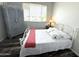 Bright bedroom with a white metal frame bed and a unique cabinet, illuminated by natural light at 16013 S Desert Foothills Pkwy # 2056, Phoenix, AZ 85048
