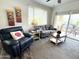 Comfortable living room with a sofa, arm chair, and a sliding glass door to a balcony with outdoor seating at 16013 S Desert Foothills Pkwy # 2056, Phoenix, AZ 85048