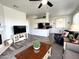 Open-concept living room with a view of the kitchen area, featuring updated flooring and bright lighting at 16013 S Desert Foothills Pkwy # 2056, Phoenix, AZ 85048