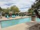 Inviting community pool with sun loungers, lush landscaping, and pergola at 16013 S Desert Foothills Pkwy # 2056, Phoenix, AZ 85048