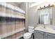 A functional bathroom with a patterned shower curtain, modern toilet, vanity with sink, and medicine cabinet at 16246 W Talara Way, Surprise, AZ 85374