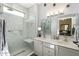Renovated bathroom showcasing a glass shower, a built-in seat, double sinks and framed mirrors at 16246 W Talara Way, Surprise, AZ 85374