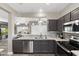 Modern kitchen with stainless steel appliances, granite counters, and dark wood cabinets at 16246 W Talara Way, Surprise, AZ 85374
