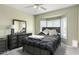 Inviting main bedroom with a bay window, ceiling fan, and dresser with mirror at 16246 W Talara Way, Surprise, AZ 85374