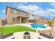 Expansive backyard with in-ground pool, artificial grass, outdoor kitchen, and seating area with a fire pit at 17424 W Willow Ave, Surprise, AZ 85388