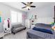 Bedroom featuring a ceiling fan, gray furniture, wall decorations, and natural light from a shuttered window at 17424 W Willow Ave, Surprise, AZ 85388