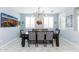 Well-lit dining room with a modern chandelier and seating for six around a dark wood table at 17424 W Willow Ave, Surprise, AZ 85388