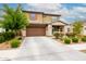 Inviting two-story home boasts a two-car garage and lush landscaping enhancing its curb appeal at 17424 W Willow Ave, Surprise, AZ 85388