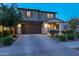 Beautiful home with a well-manicured lawn, stone accents, and a spacious driveway leading to a two-car garage at 17424 W Willow Ave, Surprise, AZ 85388