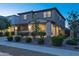 Charming two-story home featuring stone accents, a covered porch, and professionally landscaped front yard at 17424 W Willow Ave, Surprise, AZ 85388