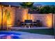 Backyard fire pit area with cushioned seating and ambient lighting, creating an ideal outdoor gathering space at 17424 W Willow Ave, Surprise, AZ 85388