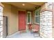 Inviting entryway featuring a red front door, stone accents, and a charming seating area at 17424 W Willow Ave, Surprise, AZ 85388