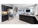 Spacious kitchen with a stainless steel refrigerator, granite countertops, and an open view of the living area at 17424 W Willow Ave, Surprise, AZ 85388