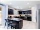 Modern kitchen featuring dark cabinetry, granite countertops, stainless steel appliances, and a breakfast bar at 17424 W Willow Ave, Surprise, AZ 85388
