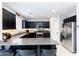 Stylish kitchen with granite counters, stainless appliances, dark cabinets, and tiled floors at 17424 W Willow Ave, Surprise, AZ 85388