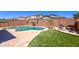 Backyard with a pool, artificial turf, and a lounge area separated by a brick wall and desert landscaping at 17424 W Willow Ave, Surprise, AZ 85388