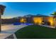 Beautiful backyard featuring a sparkling pool, manicured lawn, and an outdoor seating area with a fire pit at 17424 W Willow Ave, Surprise, AZ 85388
